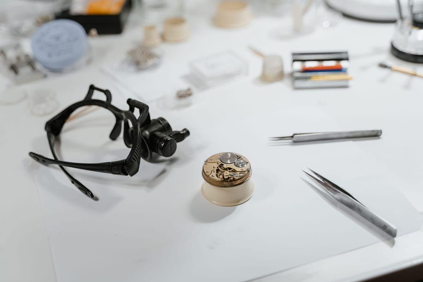 Watch repair tools and loupe on a workbench